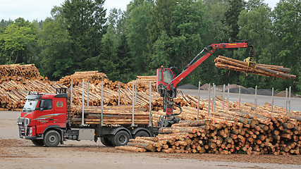 Image showing Volvo FH Truck Unloads Logs at Lumber Yard