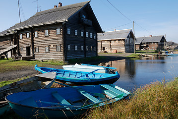 Image showing wooden houses on the shore and  boats in fishing village