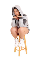 Image showing Girl sitting on chair in gray hoodie.