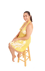 Image showing Woman in yellow dress sitting on chair.