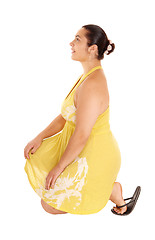 Image showing Pretty woman in yellow dress kneeling.