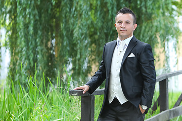 Image showing Groom posing on wooden bridge