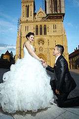 Image showing Bride and groom posing in front of cathedral