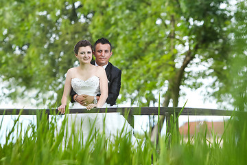 Image showing Married couple posing on wooden bridge