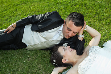 Image showing Bride and groom resting on grass