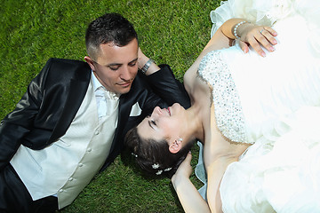 Image showing Bride and groom resting on lawn