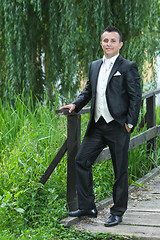 Image showing Groom on wooden bridge