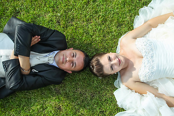 Image showing Bride and groom posing on grass