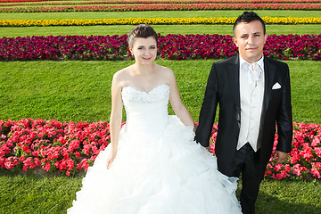 Image showing Bride and groom on lawn with flowers