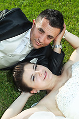 Image showing Newlyweds on grass looking at camera