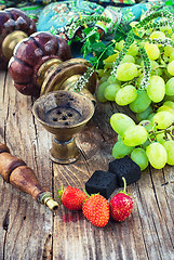 Image showing Hookah amid bunches of grapes and strawberries