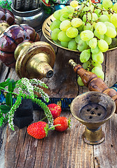 Image showing Hookah amid bunches of grapes and strawberries