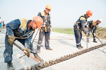 Image showing Workers level plates for next filling by concrete