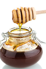 Image showing Jar of honey with wooden drizzler
