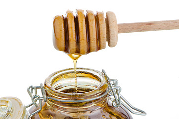 Image showing Jar of honey with wooden drizzler