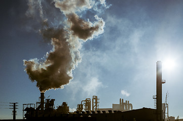 Image showing Smoking chimney  at sunset 