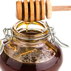 Image showing Jar of honey with wooden drizzler