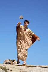 Image showing Ancient man throwing stone