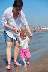 Image showing mom and baby on beach  have fun