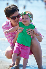 Image showing mom and baby on beach  have fun