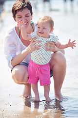 Image showing mom and baby on beach  have fun