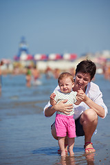 Image showing mom and baby on beach  have fun