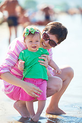 Image showing mom and baby on beach  have fun