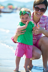 Image showing mom and baby on beach  have fun