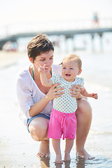 Image showing mom and baby on beach  have fun