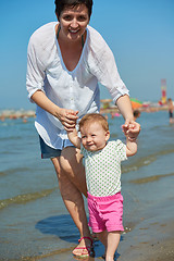 Image showing mom and baby on beach  have fun