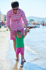 Image showing mom and baby on beach  have fun