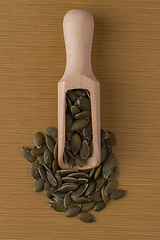 Image showing Wooden scoop with pumpkin seeds