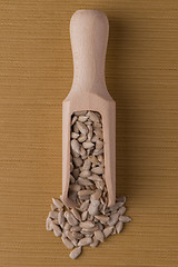 Image showing Wooden scoop with shelled sunflower seeds