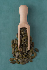 Image showing Wooden scoop with pumpkin seeds