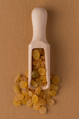 Image showing Wooden scoop with golden raisins