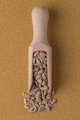 Image showing Wooden scoop with shelled sunflower seeds