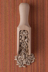 Image showing Wooden scoop with shelled sunflower seeds