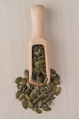 Image showing Wooden scoop with pumpkin seeds