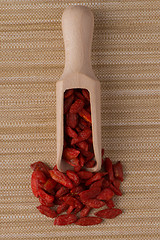 Image showing Wooden scoop with dry red goji berries