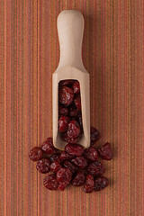 Image showing Wooden scoop with dried cranberries