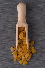 Image showing Wooden scoop with golden raisins