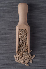 Image showing Wooden scoop with shelled sunflower seeds