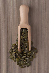 Image showing Wooden scoop with pumpkin seeds