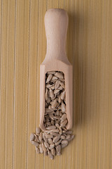 Image showing Wooden scoop with shelled sunflower seeds