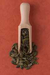 Image showing Wooden scoop with pumpkin seeds