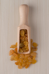 Image showing Wooden scoop with golden raisins