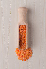 Image showing Wooden scoop with  peeled lentils