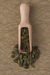 Image showing Wooden scoop with pumpkin seeds