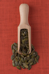 Image showing Wooden scoop with pumpkin seeds