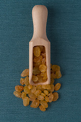 Image showing Wooden scoop with golden raisins